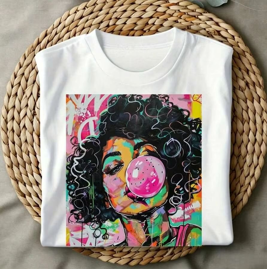 Summer Clothing Trends 2026 - เสื้อยืดพิมพ์ลายสาวผมหยิกสไตล์ป๊อปอาร์ต ฟังกี้ วีคเอนด์ ไวบ์ส กำลังเป่าหมากฝรั่ง สำหรับผู้หญิง